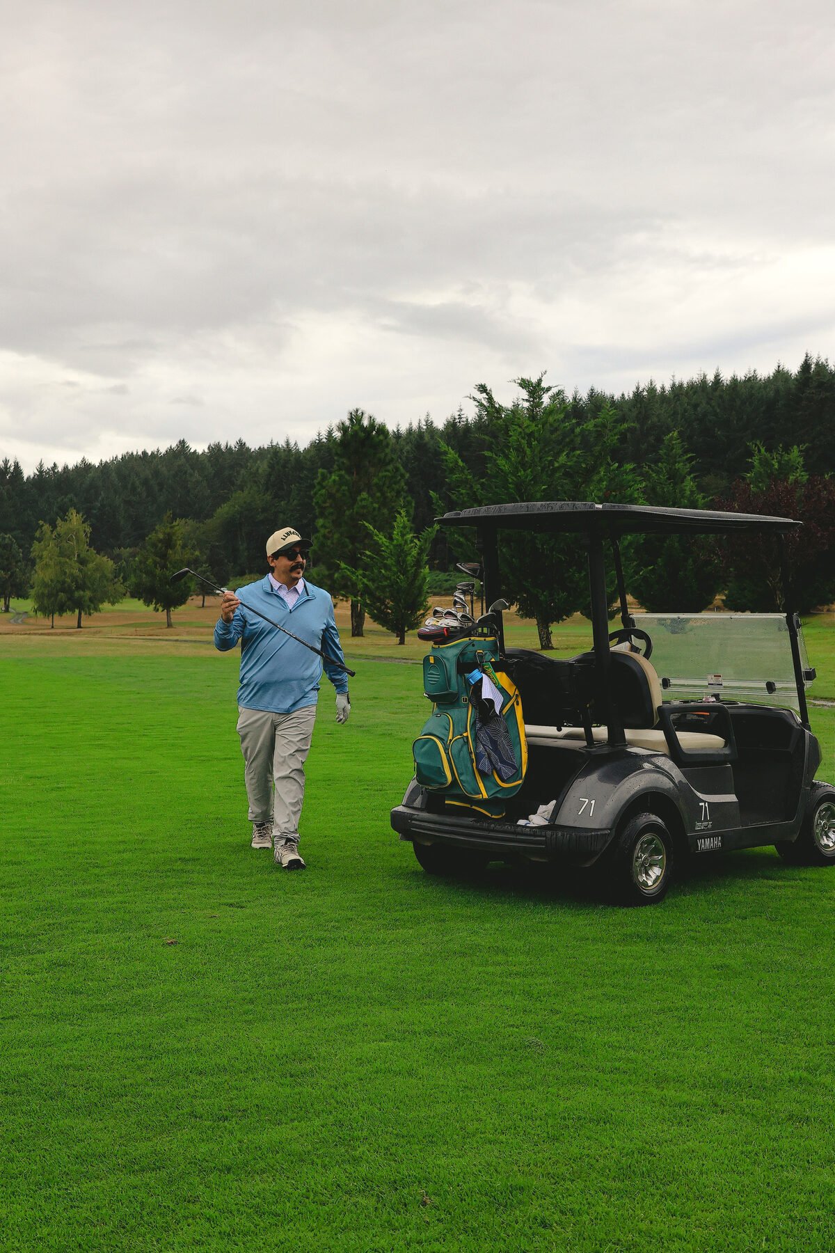 A golfer walking back to the cart, bag loaded