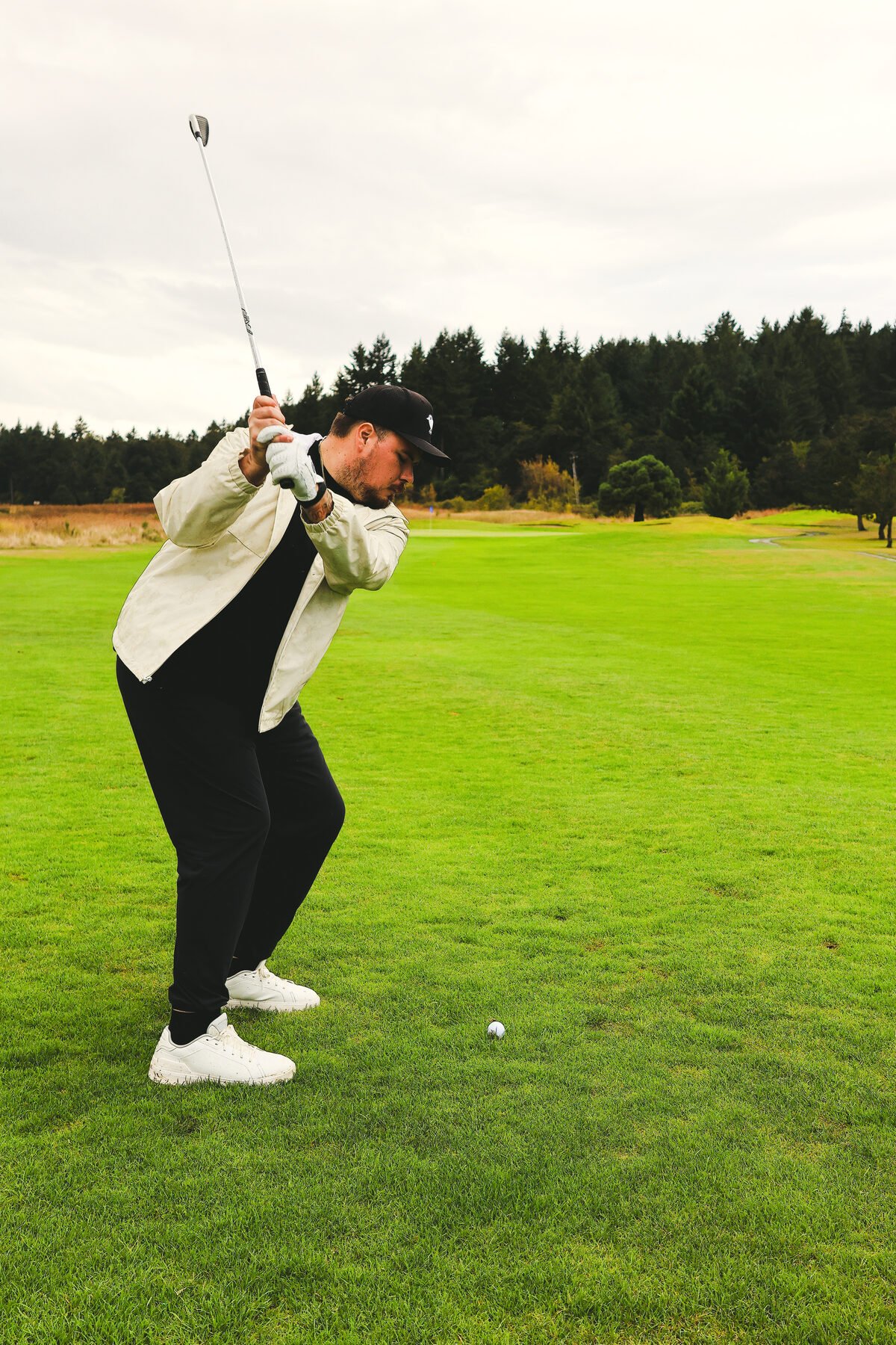 Backswing at the top, driver loaded, fairway open ahead