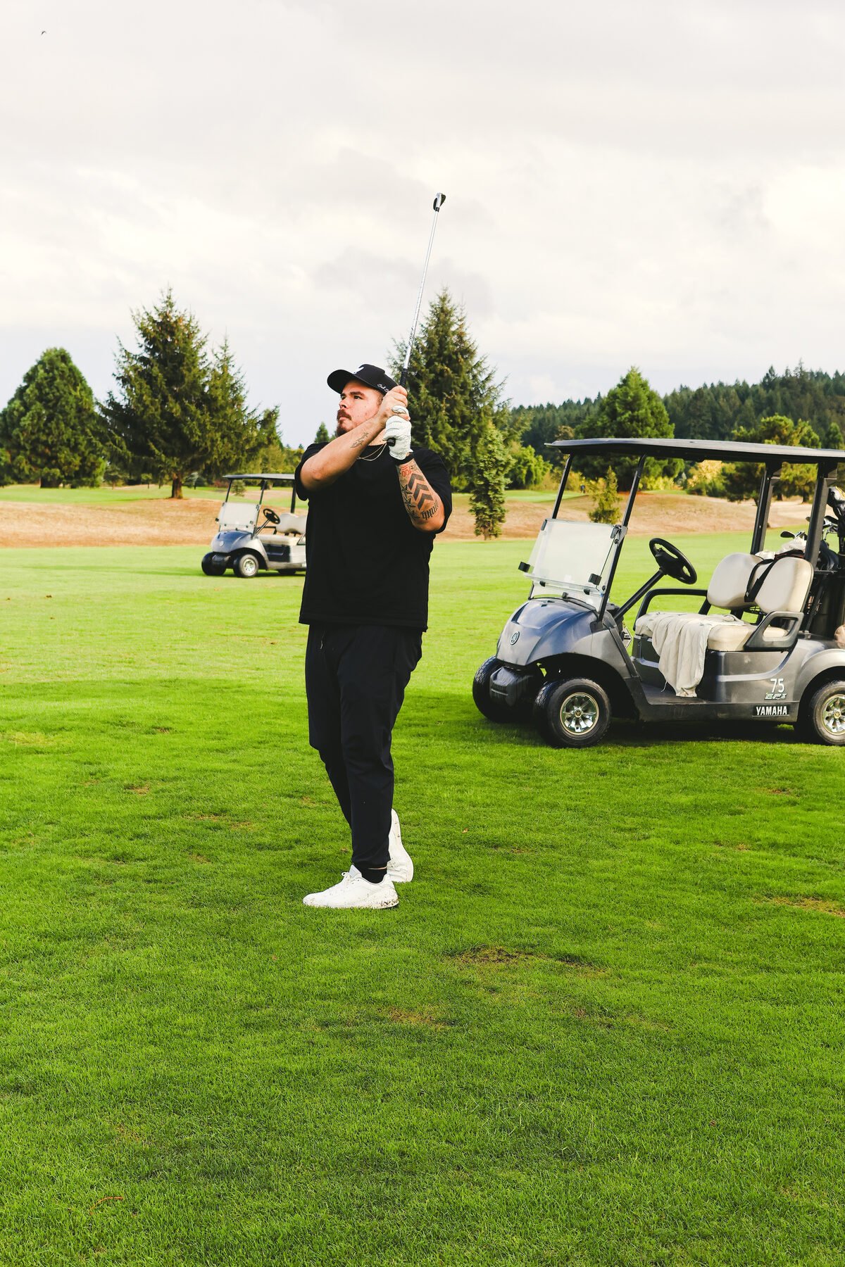 Swing off the tee with carts parked behind